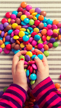 Anonymous preschool girl playing with colorful sweets
