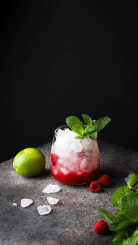 Drink with ice in a glass with raspberries