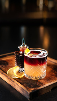 Cocktail on a wooden stand decorated with orange zest