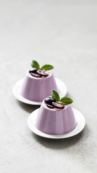 Creamy berry dessert, black grape Panna Cotta on a plate