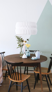 Round table and old chairs in front of twotone wall