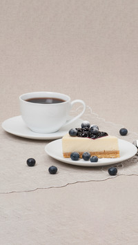 Cheesecake with blueberry jam and berries on white plate