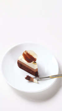 Slice of Three Chocolate Mousse Cake on white plate