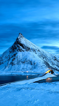 Fredvang Bridge set against pyramid shaped mountain at nigh