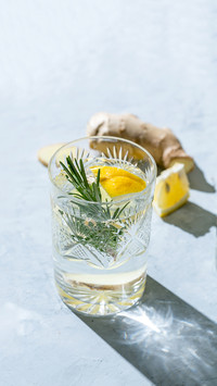 Glass of Detox infused water with lemon, ginger and rosemary