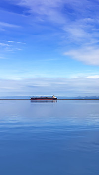 Ferry travels at a distance near the horizon's edge