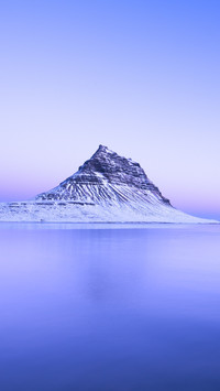 The rosy glow of the sunset is hidden on the summit of
