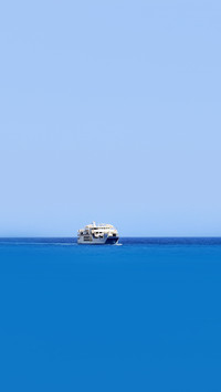 Marine blue sea and a small ship at the horizon