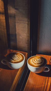 Coffee latte in sunshade on wood table