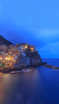 Manarola village on cliff rocks and sea at sunset