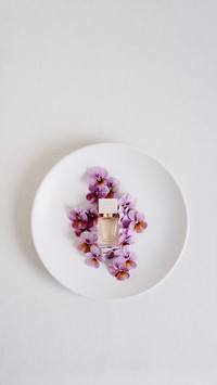 Purple pansy flowers, plate and perfume bottle
