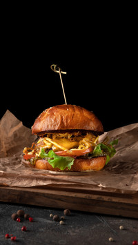 Big classic burger with beef on a black background