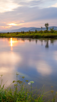 The slanting sun sets on the small river and the boats