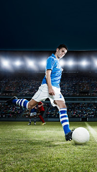 Soccer player kicking ball on field
