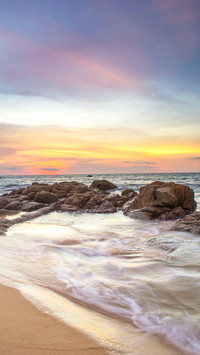 Beach and waves hitting on coast at sunset long exposure