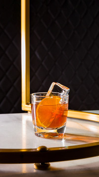 Cocktail with ice, oranges in a glass that is on the table