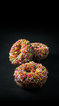 Closeup of multi colored donuts on black background