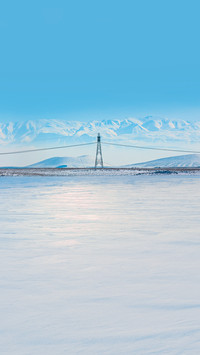 High voltage power lines with snowy mountains