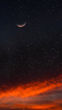 The night moon hangs low, reflecting on the vast sky