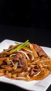 Stir fry a plate of beef chow fun with wok gas