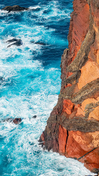 Waves crash against the cliff