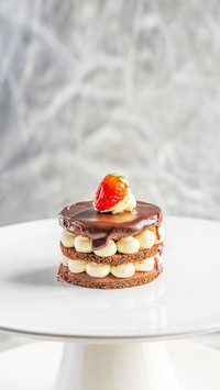 Piece of cake with cream and berries on a white plate