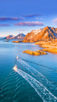 Aerial view of fishing boats, rocks in the blue sea