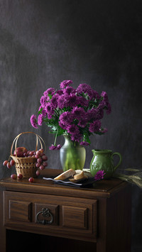 Purple flowers and grapes still life
