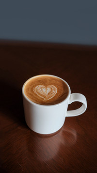 Cup of coffee latte on wooden table, latte art top view