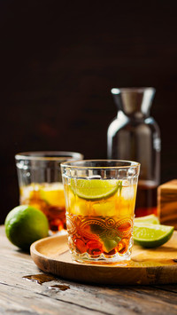 Strong golden rum with lime and ice, selective focus