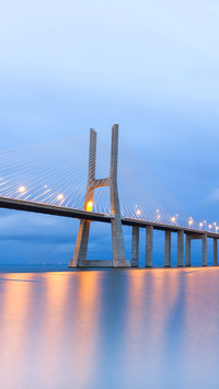 Vasco da Gama bridge lit at sunset in Lisbon