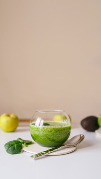 Fruits, spinach and lemon juice in globe glass