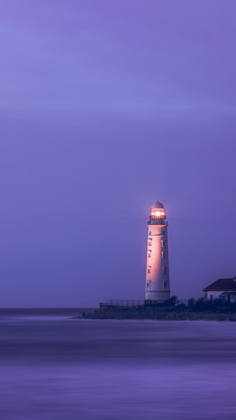 A lighthouse on the coast of the sea at dusk preview