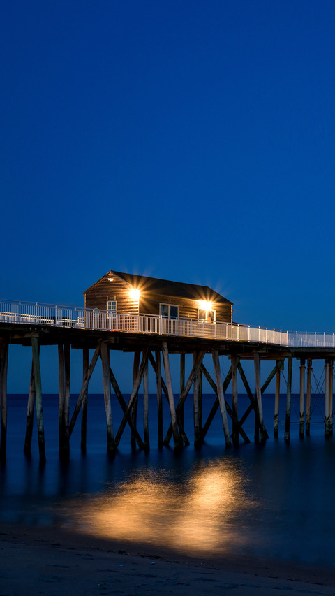 Full moon rising near a fishing pier preview