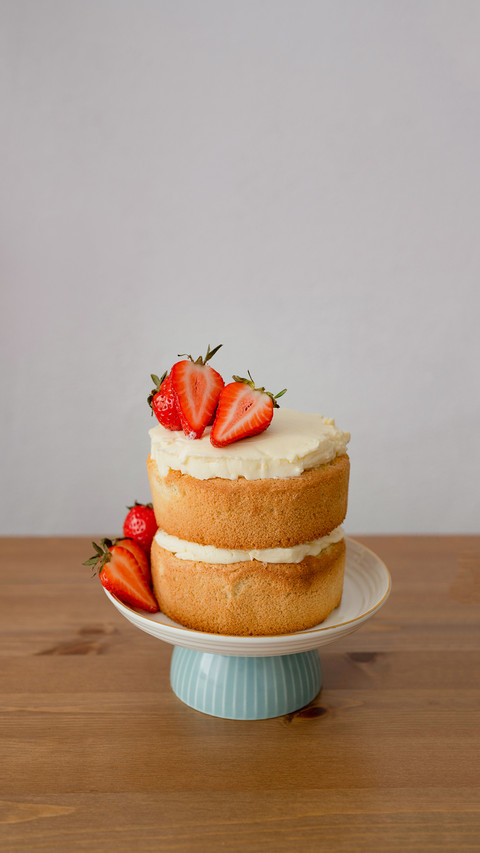 Strawberry cake on stand on wooden table preview