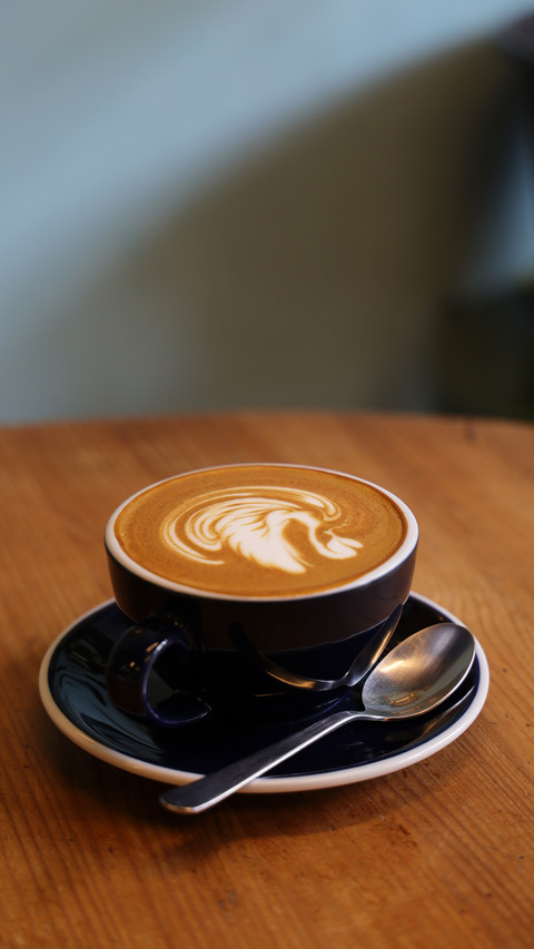 Coffee latte art on the wood desk in coffee shop cafe preview