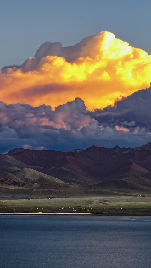 The sunset reflects on the snow-capped mountains. preview