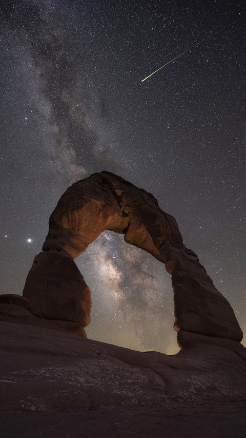 Night hiker under Delicate Arch and the Milky Way Galaxy preview