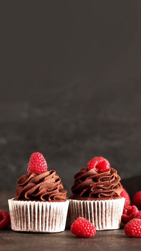 Tasty chocolate cupcakes with raspberry on dark background preview
