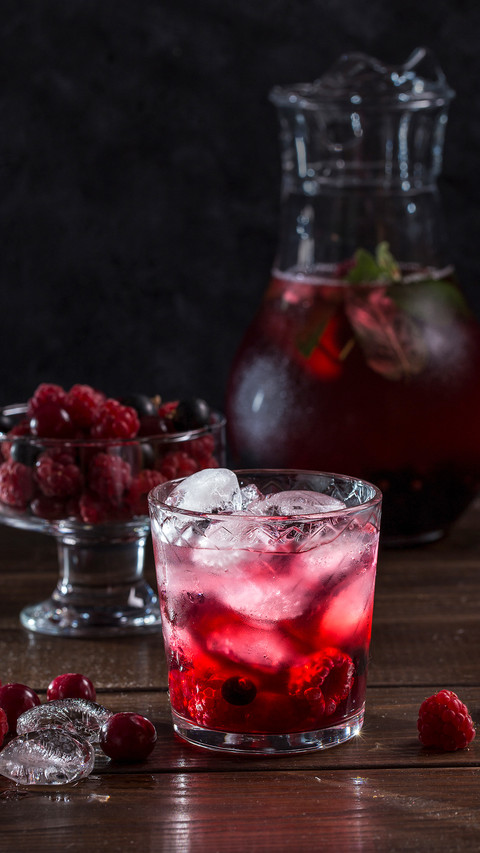 Berry lemonade in a transparent glass on a dark background preview