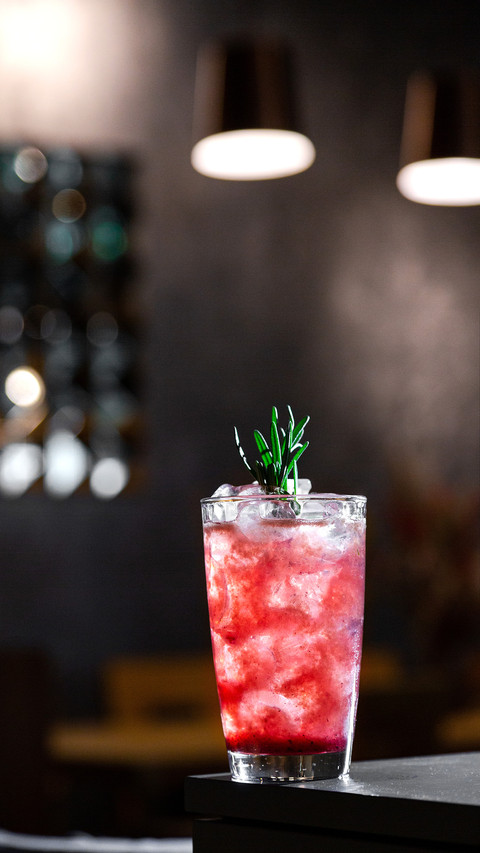 A cocktail with syrup, ice and rosemary in a glass preview