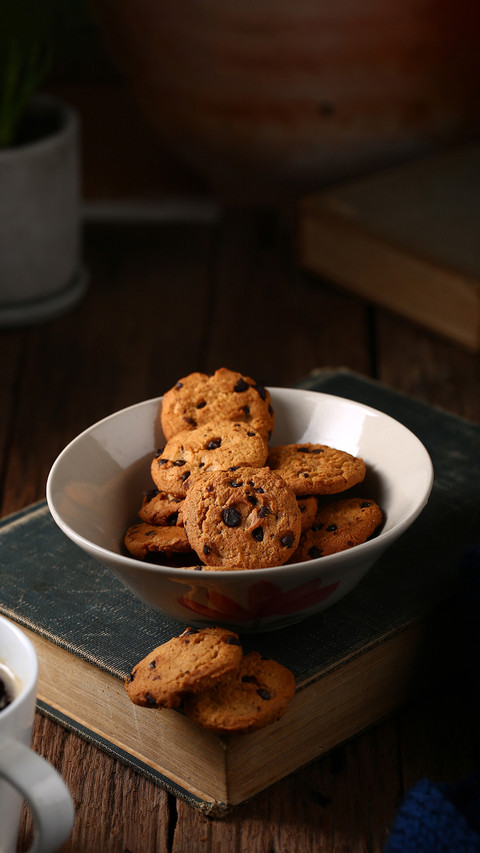 The chocolate chip cookies are in a bowl on the old book preview