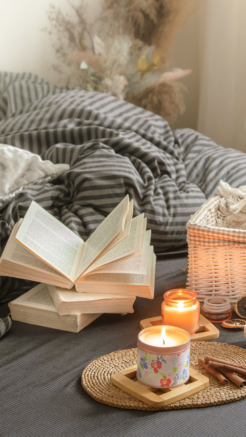 Candles and a Book Lie on the Bed in the Living Room preview