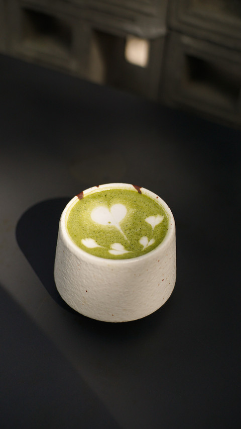 Hot green tea latte with heart and love latte art in a cup preview