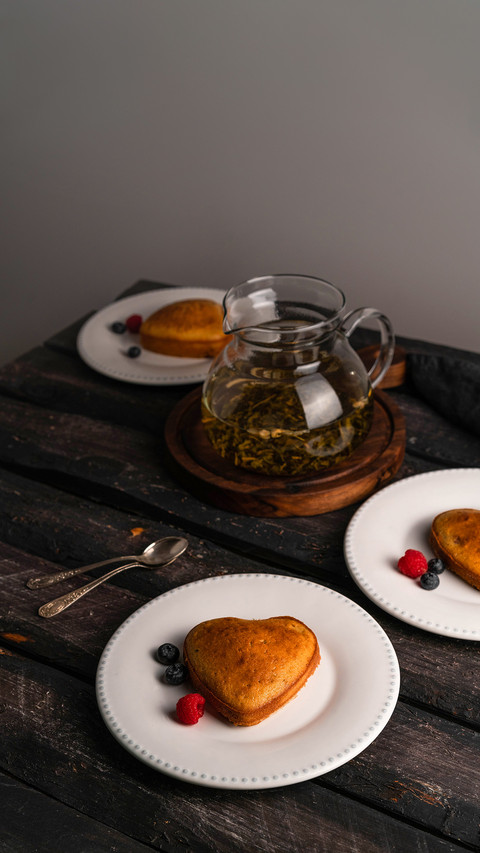 Heart-shaped cake and berries dessert on white plate against preview