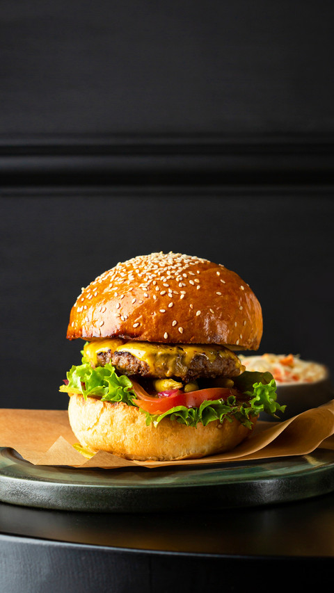 Close up of burger on black table and potato fries preview