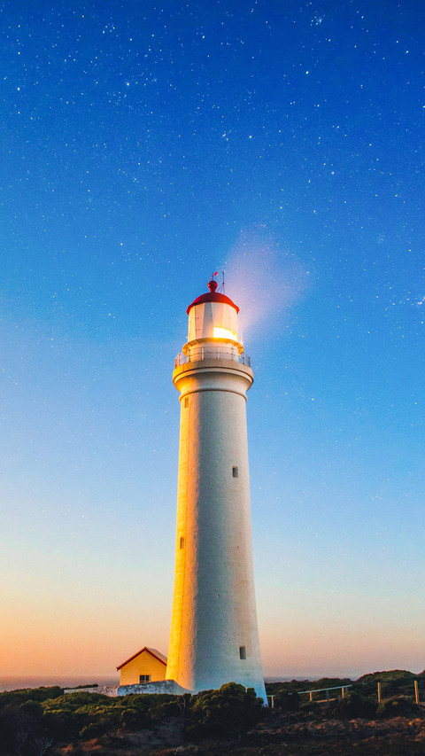 Lighthouse seaside with stars and sunset preview
