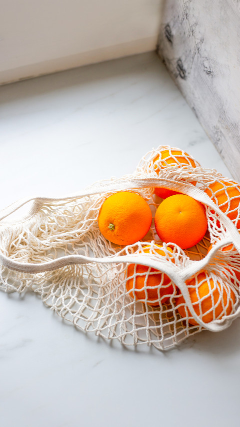 Picked orange fruits in cloth bag on marble background preview