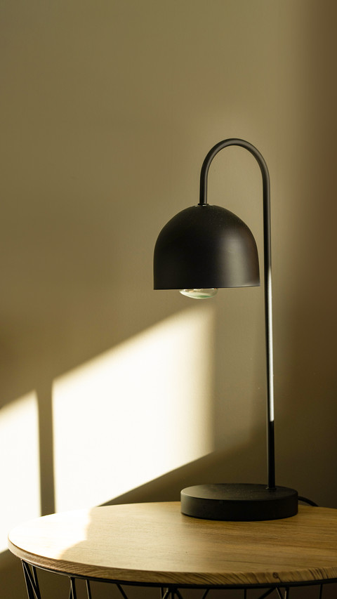 Black lamp on the table with sun light near bed preview