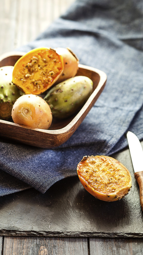 Wooden bowl of prickly pears on cloth and slate preview